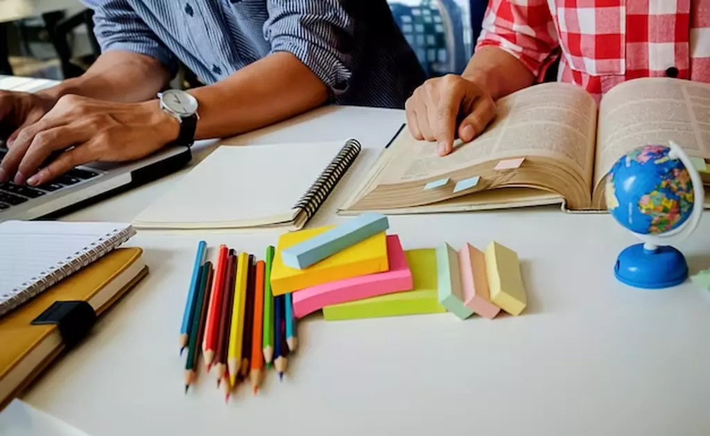 matite colorate su scrivania persona al pc